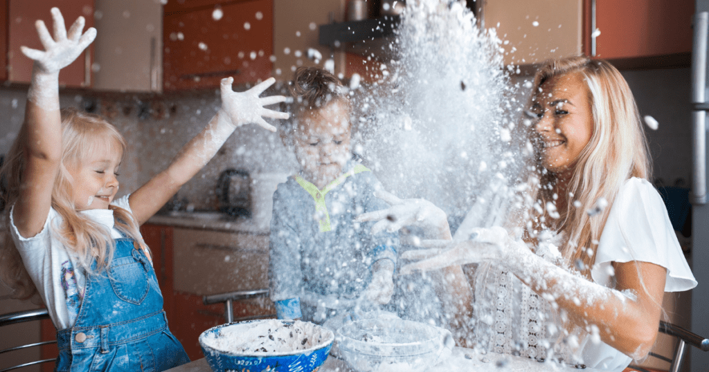 Kitchen layout - children and woman throwing flour in the air in a kitchen