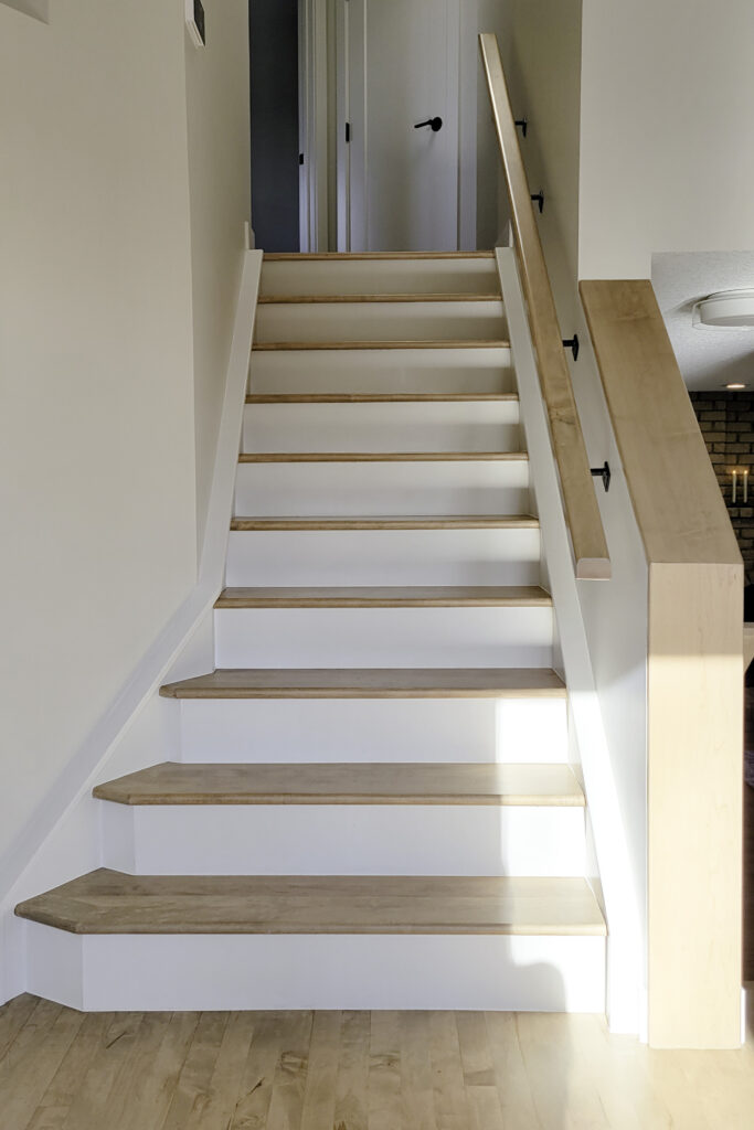 High contrast stairs with white risers and hardwood treads.