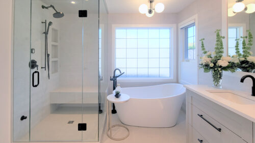 Ensuite bathroom with steam shower encased in glass and stand alone tub with a raised back for luxurious bubble baths.