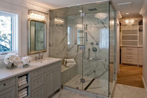 Divine double steam shower with a bench to enjoy long showers. Bold strong black veining is throughout the grey tiles.