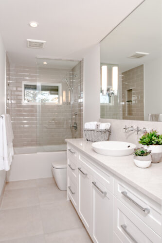Neutral bathroom white and grey accents. Grey tiled shower/ tub combination.