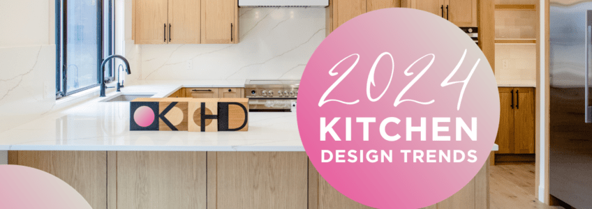 Text reads kitchen design trends 2024 in a pink circle overlaying a kitchen with light warm wood cabinets and light natural stone look countertops. Globe pendant lights, pot lights and a plastered hood fan finish off this look.